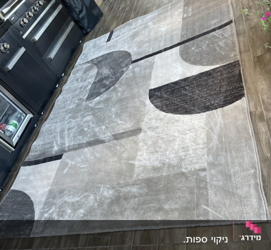 שטיח אפור על רצפת עץ ליד תנור